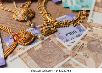 Concept Of Black Money, IT Raid, Confiscated Money And Gold Price In India Showing Indian Currency Notes With Jewelry.