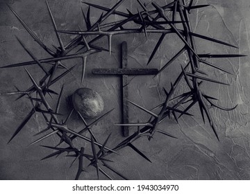 Concept Black and white Gothic Easter background with crown of thorns, dyed egg and black wooden cross Horizontal image