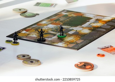 The Concept Of A Board Game And Leisure. Adults, Teenagers Or Children Play Board Games. Hands With Playing Cards, Chips And Placed Figures Of Characters On The Table