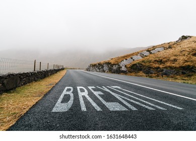 Concept Of BREXIT.  Road Marking With The Word Brexit Painted On Remote Road A Misty Day. Concept Uncertainty And Solitude