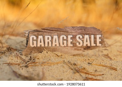 Concept, Business And Finance. In The Sand Against The Background Of Yellow Grass There Is A Sign With The Inscription - GARAGE SALE