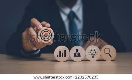 concept of business goals, strategy and planning for success, businessman hand holding circle stick with dart board icon, clearly shows the goals of the business with working systematically.