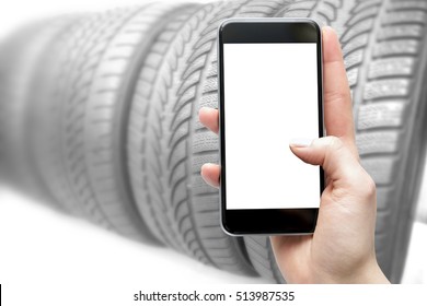 Concept Of Of Buying, Look For Tires On The Web. Smartphone In The Hands Of A Woman With A Blank Screen And A Blurred Background.