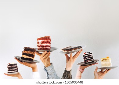 Concept for cafe or bakery with desserts: plates with different cakes in people's hands, place for your text