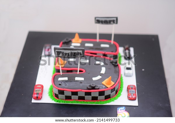 Concept of Cake structure.concept of cake structure\
for five year celebration of a child with racing track with\
cars.