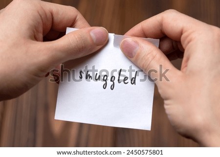 Concept of cancelling. Hands closeup tearing a sheet of paper with inscription smuggled