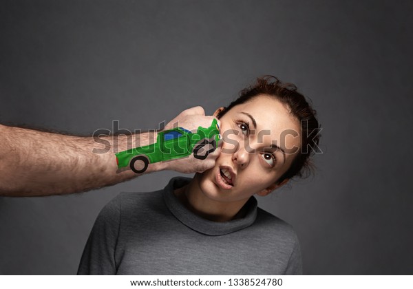 the concept of car\
accidents, insurance claims . A woman is punched in the face . on\
fist drawn car.