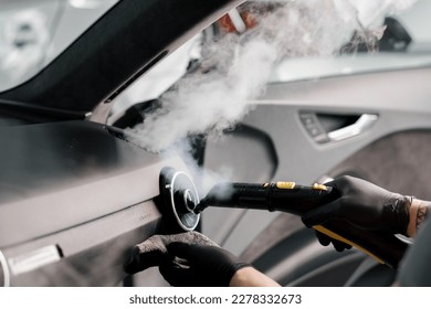 The concept of car cleaning and detailing The detailing master cleans the car interior with a hot steam cleaner Cleaning car interior - Shutterstock ID 2278332673