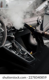 The concept of car cleaning and detailing The detailing master cleans the car interior with a hot steam cleaner Cleaning car interior - Shutterstock ID 2278340859