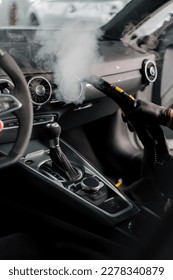 The concept of car cleaning and detailing The detailing master cleans the car interior with a hot steam cleaner Cleaning car interior - Shutterstock ID 2278340879