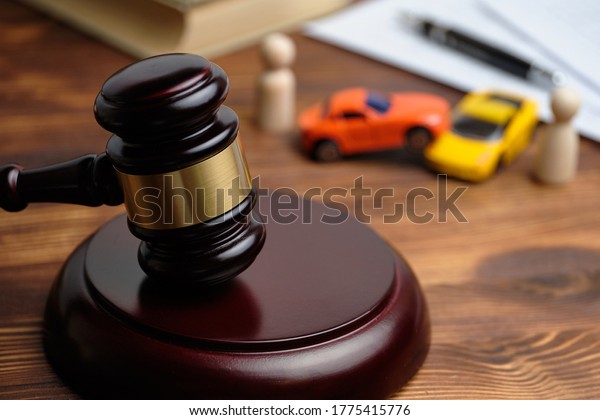 The concept of a car owner accident
lawsuit. Judge hammer next to car models and
documents