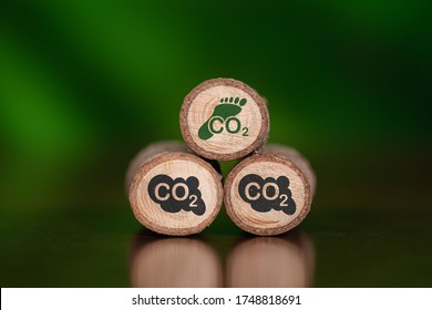 Konzept des CO2-Fußabdrucks mit Symbolen auf Holzhölzern