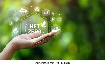 The concept of carbon neutral and net zero. natural environment A climate-neutral long-term strategy greenhouse gas emissions targets with green net center icon on hand cap and green background - Shutterstock ID 2141948313