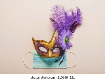 Concept of carnival during covid-19. Venetian carnival mask with protective surgical mask over light background. Carnival celebration concept - Shutterstock ID 2106684221