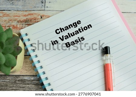 Concept of change in valuation basis write on book isolated on Wooden Table