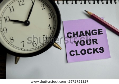 Concept of Change your clocks write on sticky notes isolated on Wooden Table.