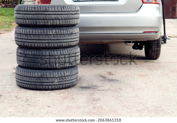 The concept\
of changing seasonal tires on a car. Folded tires on the background\
of a car on the street ,\
close-up