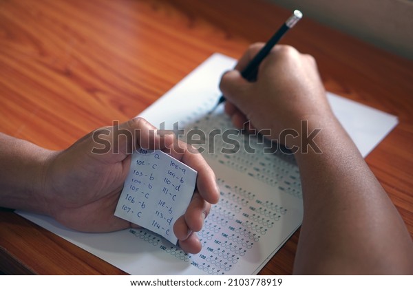 Concept : Cheat the test. Selective focus on hand\
hold small piece of paper that wrote answer during doing test.     \
                            \

