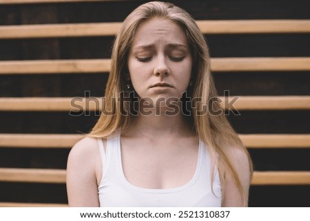Concept of cheerless and joyless, disappointed hipster girl feeling sad and melancholy while standing on publicity area, regrettable offended Caucasian woman 20s with emotional pain on face