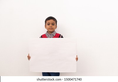 Concept Of Child Protest Showing With Young Boy Holding Large White Placard On Isolated Background.