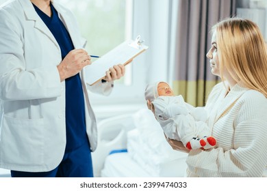 Concept of childbirth and healthcare professionals. Shallow field of view. A doctor or male midwife visiting mother after birth or cesarian holding a new born baby in her arms at the hospital room. - Powered by Shutterstock