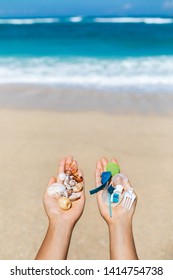 Concept of choice: save nature or continue to use disposable plastic. One hand holding beautiful shells, in the other - plastic waste. Ocean and tropical beach on background. Environmental pollution