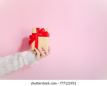 concept for christmas and new year event with beauty hand woman with winter cloth holding gift and give it to friend with isolated pink background - Shutterstock ID 777121951