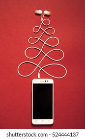 Concept. Christmas Tree From Smartphone And Headphones. Happy New Year.