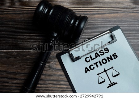 Concept of class actions write on clipboard isolated on Wooden Table. Representing legal compliance and litigation exposure assessment