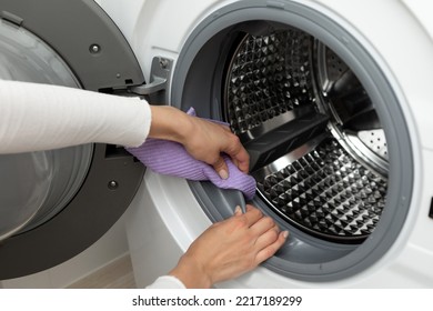The concept of cleaning the details of a washing white machine, a stainless steel drum inside, close-up, no face