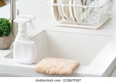 Concept Of Cleaning Product Spray Bottle And Rag In Modern Kitchen Beside Sink To Wipe The Counter Table Surface.