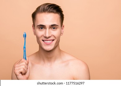 Concept Of Cleaning Teeth Is A Correct Way. Close Up Photo Of Happy Young Man With Big Toothy Smile And Blue Toothbrush Isolated On Pastel Beige Background