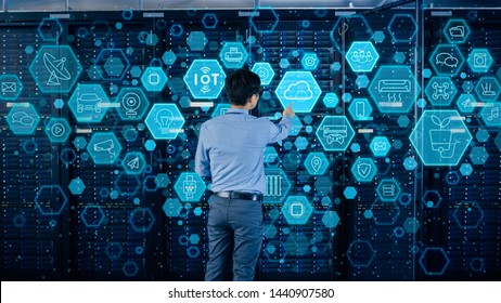 Concept of Cloud Data Storage. Shot In the Modern Data Center: IT Engineer Standing Beside Open Server Rack Cabinet and Touching Digital Illustrative Icons with Different Symbols and Visualisations.