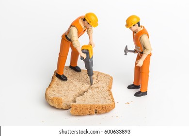 The concept of a collective solution to any problem. Miniature toy workers crash the bread. Close-up view. - Powered by Shutterstock