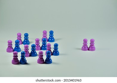 Concept With Colored Pawns. Discrimination. Straight Couples Grouped Together While A Gay Couple Stands Apart.