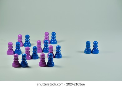 Concept With Colored Pawns. Discrimination. Straight Couples Grouped Together While A Gay Couple Stands Apart.