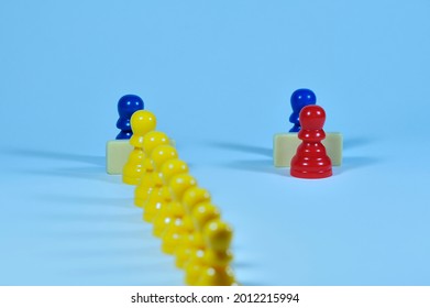 Concept With Colored Pawns. Privileges. An Individual Figure Is Served At One Counter While Many Others Wait Their Turn At Another Counter.