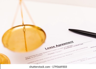 Concept Of Commercial, Lease, Tenancy, Contract, Property Or Commercial Laws: The First Page Of Lease Agreement Is Placed Near Blurred Justice Scales.