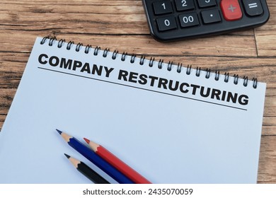 Concept of Company Restructuring write on book isolated on Wooden Table.