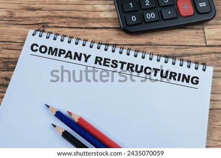 Concept of Company Restructuring write on book isolated on Wooden Table.