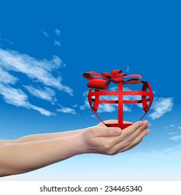 Concept or conceptual 3D red abstract heart sign or symbol with ribbon held in hands by a man, woman or child on blue sky background, metaphor for love, holiday, gift, care, valentine or romantic - Shutterstock ID 234465340