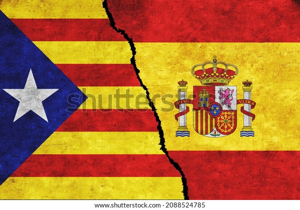Concept of a conflict between Spain and\
Catalonia with painted flags on a wall with a\
crack