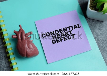 Concept of congenital heart defect write on sticky notes isolated on Wooden Table.
