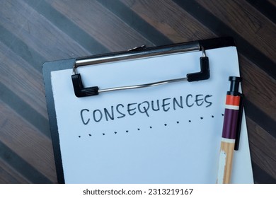 Concept of Consequences write on paperwork isolated on Wooden Table.