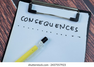 Concept of Consequences write on paperwork isolated on wooden background.