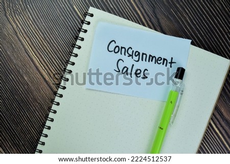 Concept of Consignment Sales write on sticky notes isolated on Wooden Table.
