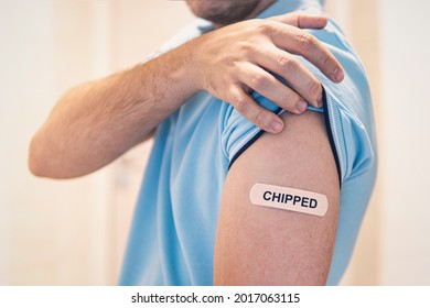 The Concept Of A Conspiracy Theory About Chipping The World's Population During Mass Vaccination Against The Covid 19 Coronavirus. The Shoulder Is Sealed With A Band-aid With The Inscription Chipped.