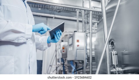 Concept Control Food Industry Banner. Factory Worker Inspecting Production Line Tanker In Of Dairy With Computer Tablet.