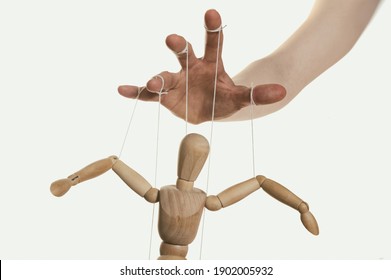 Concept Of Control. Marionette In Human Hand. Close-up.