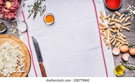 The Concept Of Cooking Raw Minced  Beef Egg Chopped Onion Knife Seasoning Paste Tomato Sauce On A White Napkin On Wooden Background Top View